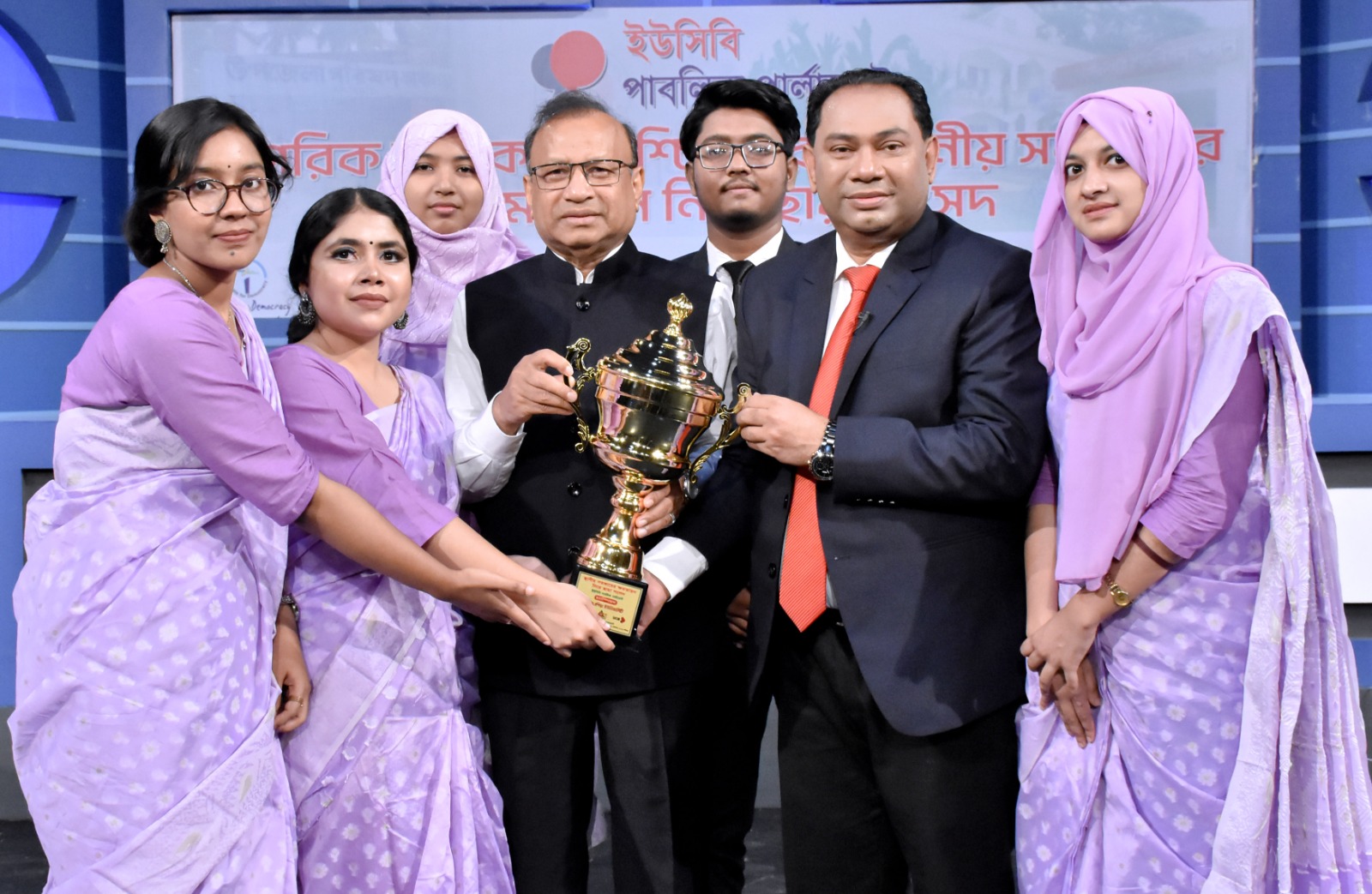  মন্ত্রী মো. তাজুল ইসলাম, এমপি ও ডিবেট ফর ডেমোক্রেসির চেয়ারম্যান হাসান আহমেদ চৌধুরী কিরণের কাছ থেকে ট্রফি গ্রহণ করছে চ্যাম্পিয়ন দল প্রাইমএশিয়া ইউনিভার্সিটির বিতার্কিকরা